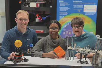 Prof. Harald Schwefel, Agnes Blaikie Fellow Dr. Mallika Suresh and A/Prof. Annika Seppälä in front of the fs-laser used to fabricate ultra high quality optical resonators